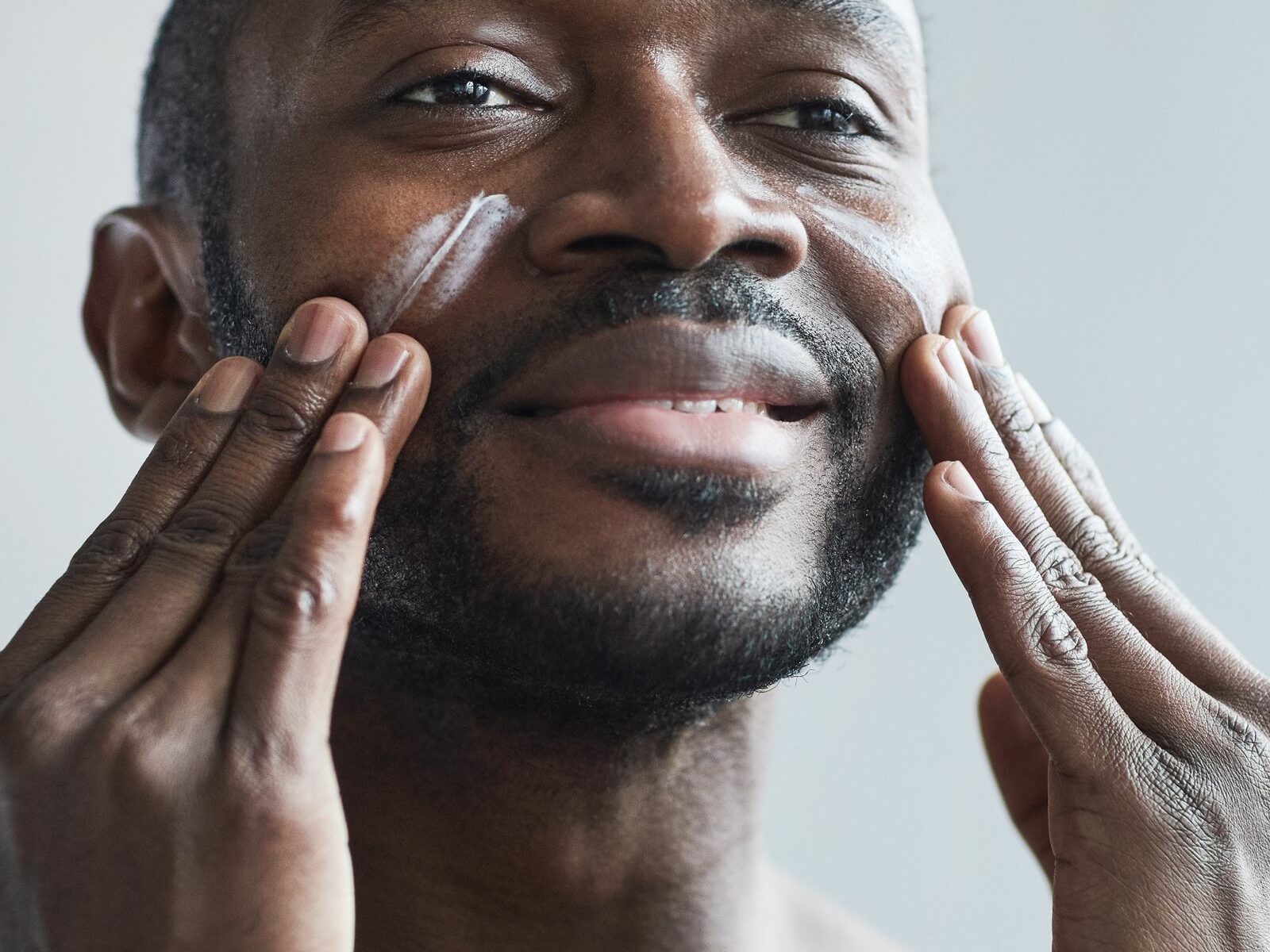 Homme appliquant une crème de soin