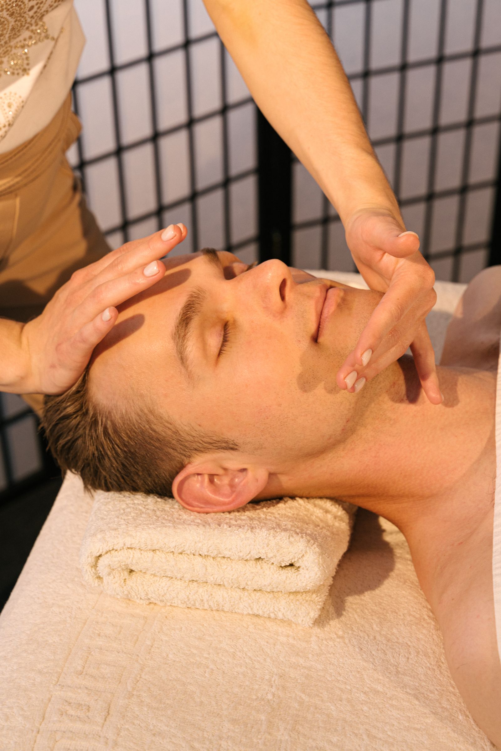 Un homme reçoit un massage du visage en institut de soin