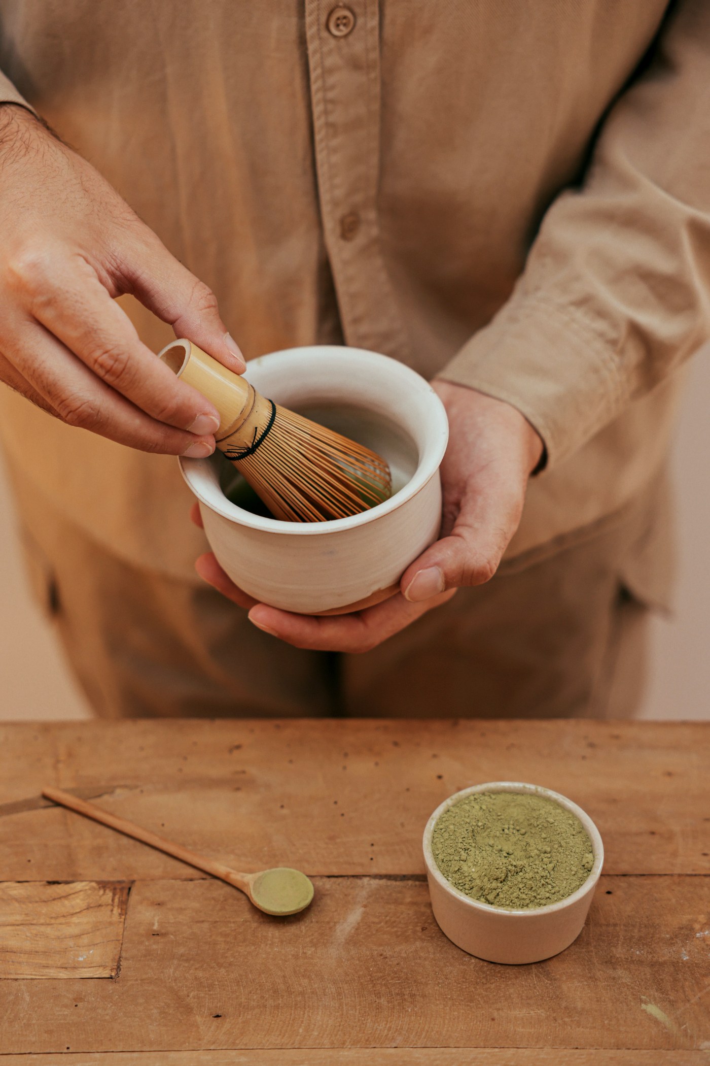 Zubereitung von Matcha, aufgeschlagen mit einem Bambusbesen