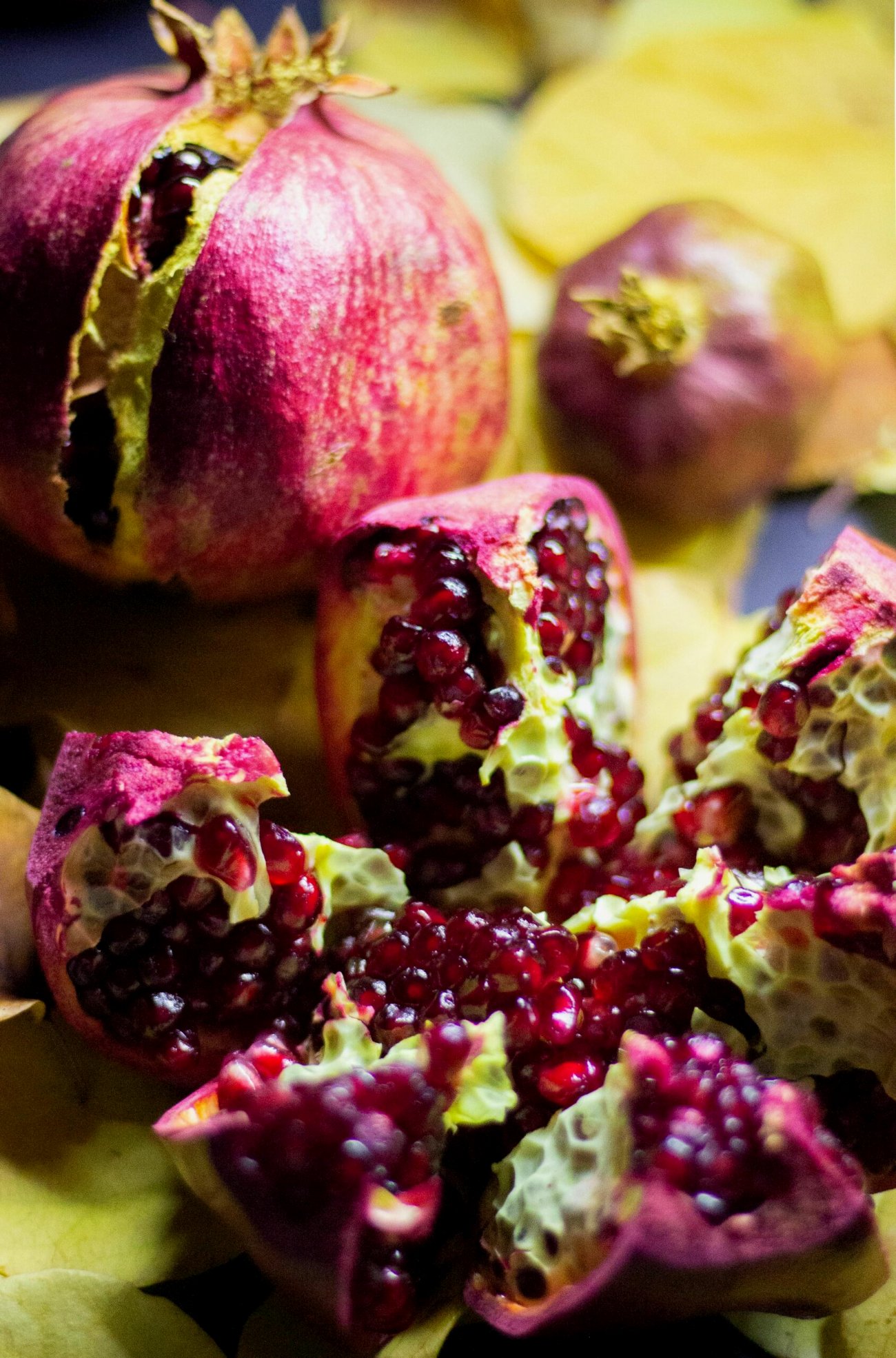 Aufgebrochene Granatäpfel und ihre roten Kerne, reich an Antioxidantien, ein Herbstobst für die Haut